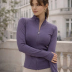 Woman wearing a fitted purple active jacket with zip front, standing outdoors in the city
