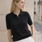 Woman wearing black short-sleeve knit polo shirt with button placket and white pants
