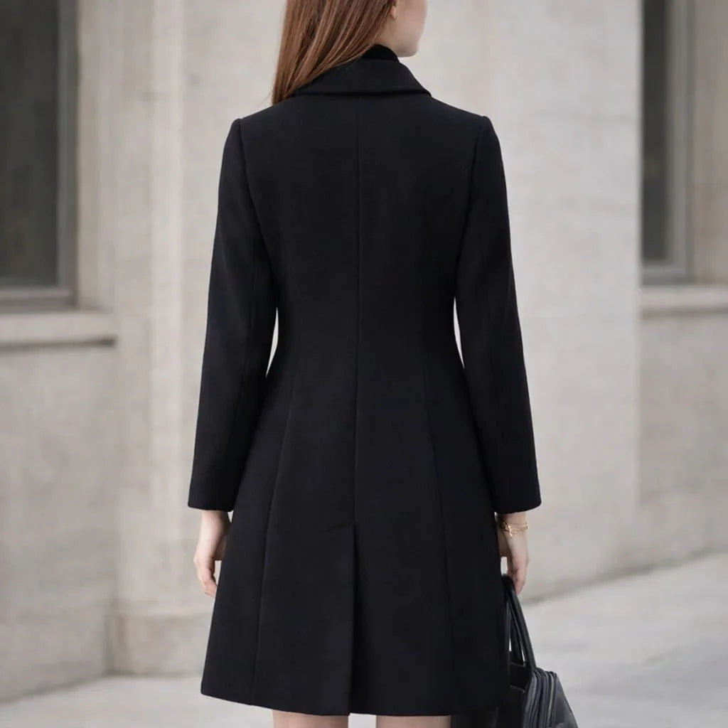 Woman wearing a black long wool coat with tailored fit, outdoor city setting, rear view