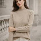 Woman wearing a beige high-neck jumper outdoors, neutral background, casual knitwear style