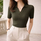Woman wearing olive green ribbed knit polo shirt and high-waisted beige trousers