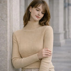 Woman wearing beige ribbed turtleneck sweater in outdoor architectural setting