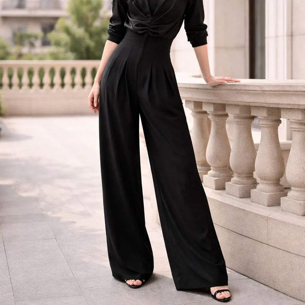 Woman wearing black tailored wide-leg trousers and heels on outdoor terrace