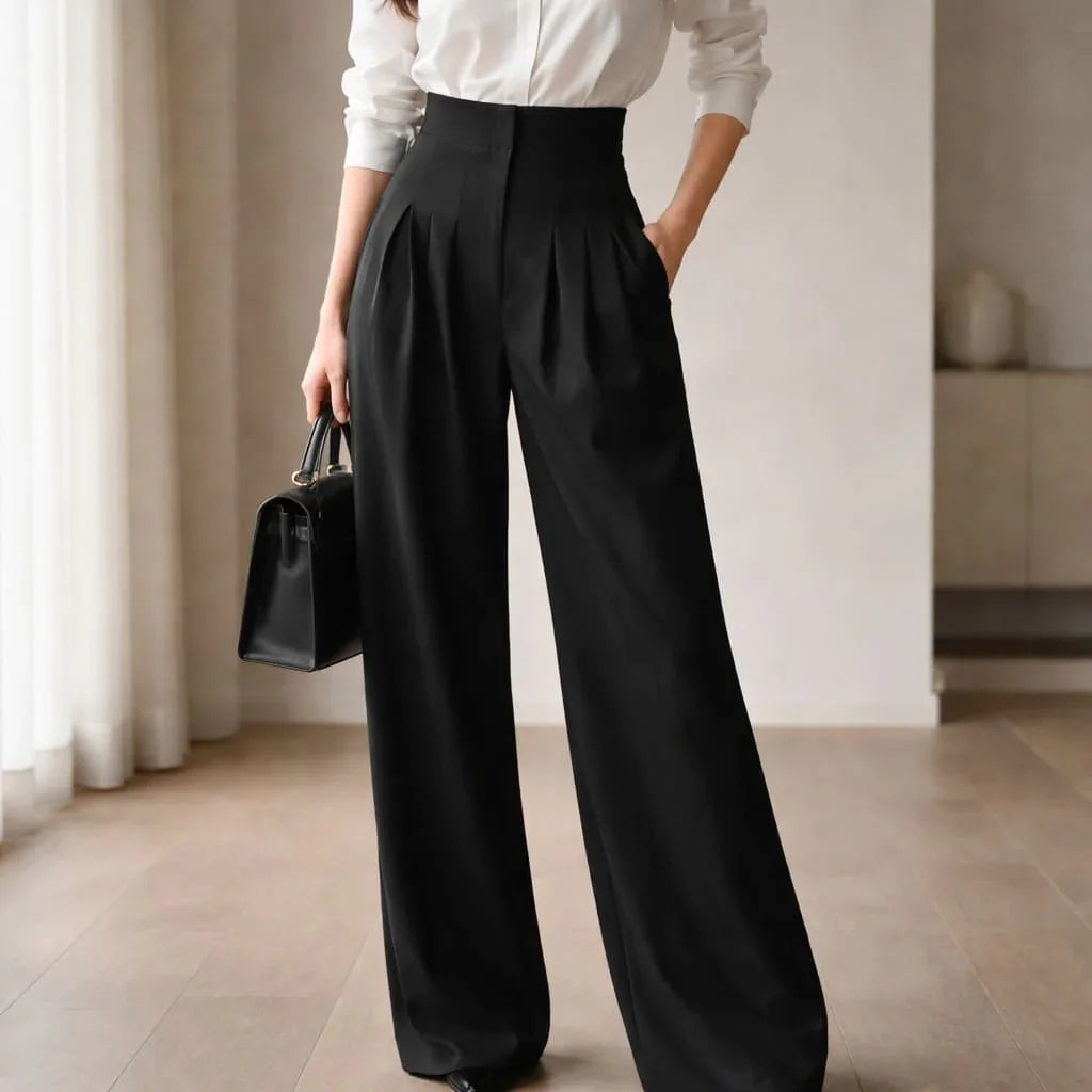Woman wearing black high-waisted wide-leg tailored trousers and white shirt indoors
