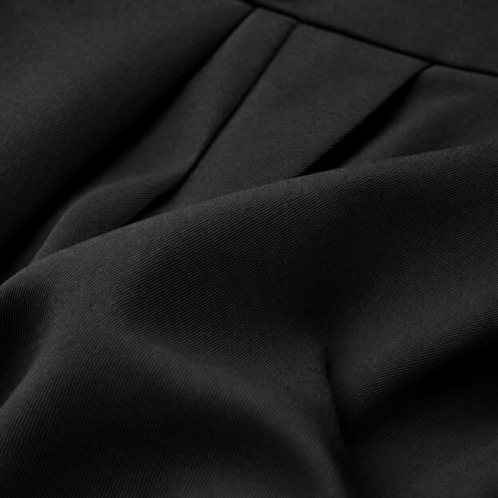 Close-up of black tailored wide-leg trousers fabric with fine texture and neat pleats