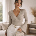 Beige ribbed flared-sleeve blouse with deep V-neck, styled with white pants and gold accessories