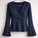 Navy blue flared sleeve blouse with ribbed texture and V-neck, hanging on hanger