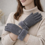 Woman wearing grey winter gloves with faux fur cuffs and cozy ribbed sweater indoors