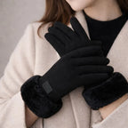 Woman wearing black winter touch gloves with faux fur cuffs and beige coat