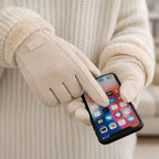Beige touchscreen winter gloves used with smartphone, cozy knit sweater in background