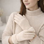 Woman wearing soft beige winter gloves with faux fur cuffs and a ribbed knit sweater