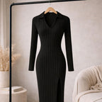 Black ribbed knit v-neck dress with long sleeves and side slit, hanging on a rack
