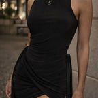 Woman wearing a sleeveless black contour dress with ruched side detail, outdoor setting